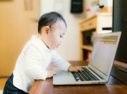 ノートパソコンを触る赤ちゃん